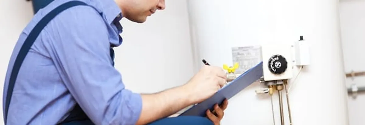 Water heater repair technician inspecting the unit and recording service notes in Fort Wayne, IN